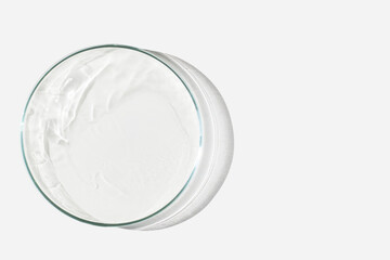 Petri dish on a light background with liquid, water. Splashes of water. The waves in the Petri dish. View from above. Laboratory