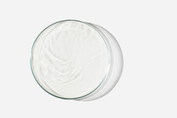 Petri dish on a light background with liquid, water. Splashes of water. The waves in the Petri dish. View from above. Laboratory