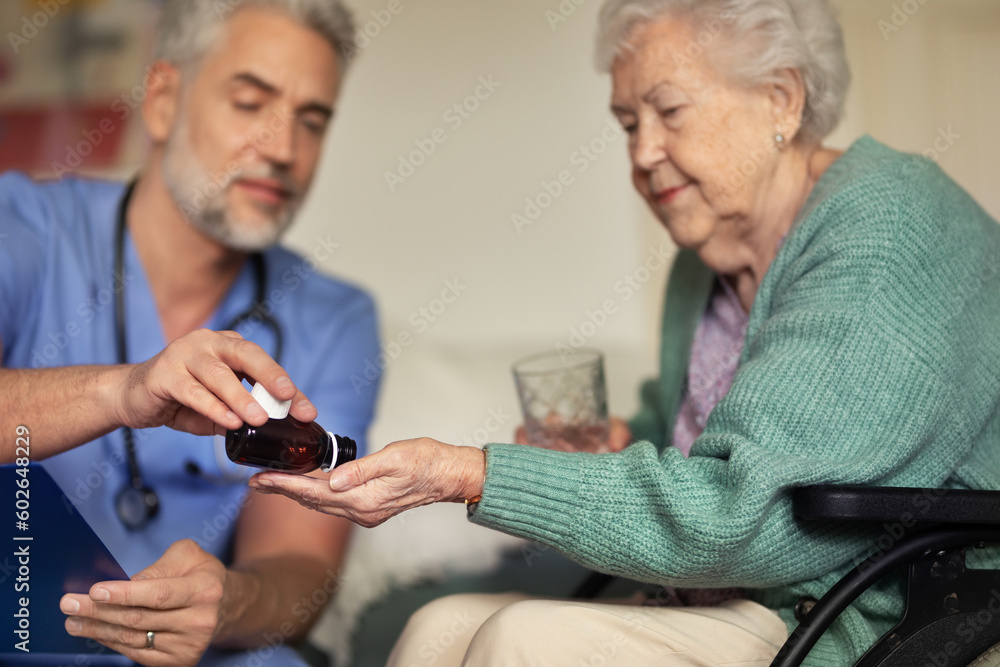 Wall mural caregiver doing regular check-up of senior woman in her home.