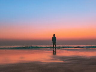 Fototapeta na wymiar person walking on the beach at sunset