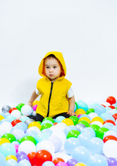 Fototapeta na wymiar Little boy playing with colourful balls. Playground joyful having fun.