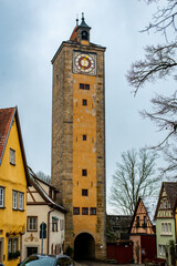Fototapeta na wymiar Colourful street of Rothenburg ob der Tauber and clock tower, the Franconia region of Bavaria, Germany. Medieval old town. The most romantic town in Germany.