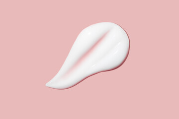 A dab of cosmetic cream. Light, smooth surface. Texture of spreadable cream. Liquid cream smear. On a pink background.