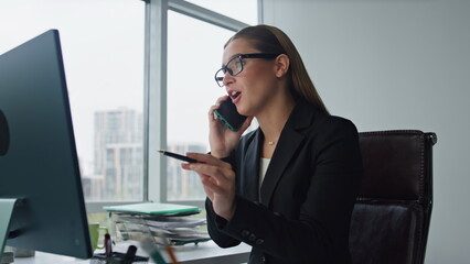 Financial advisor talking smartphone in office. Confident businesswoman working
