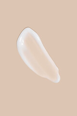 The flowing cream on a beige background. Smudged flowing smear of cosmetic cream.