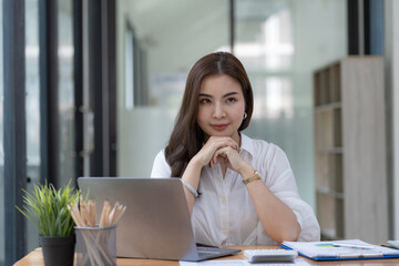 Portrait Young Asian businesswoman thinking about work at her office.