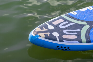 A girl in a life jacket swims on a SUP board. SUP board Stand up paddle girl boarding on lake...