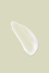 The flowing cream on a green background. Smudged flowing smear of cosmetic cream.