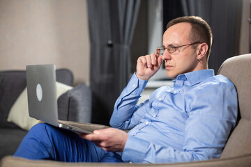 Psychologist worker stares intently at laptop screen. Man with bewilderment examines result of work done while sitting at workplace