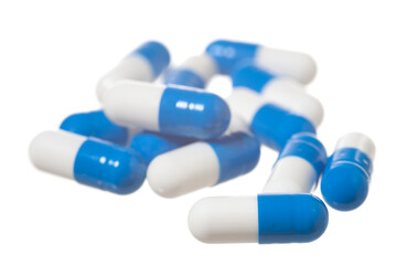 Blue pills on white. Focus on the front capsule.