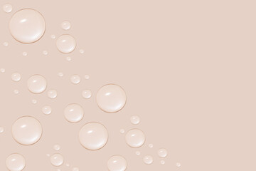 Drops of transparent gel or water in different sizes. On a beige background.