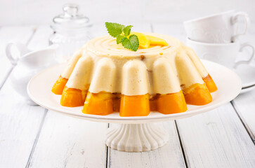 Traditional Italian mango pudding with vanilla mousse served as close-up on a classic cake plate