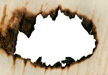 A hole in the scorched old yellow, crumpled paper. Baking paper after fire. Fire