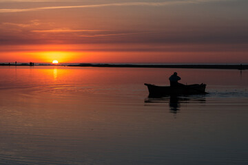 Fisherman in boat get fishing nets from river, Silhouette of fisherman,a dip net for fishing at...
