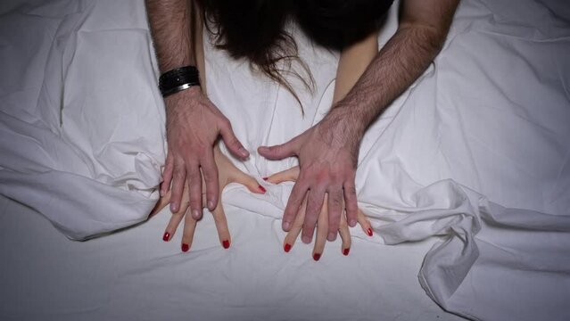 Couple engaged in sexual intercourse on bed