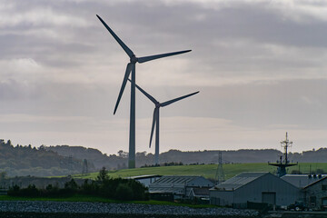 Wind power generators in the south of Ireland, landscape. Two wind turbines located in Ringaskiddy, County Cork. Cloudy overcast sky. wind turbine under white cloudy sky