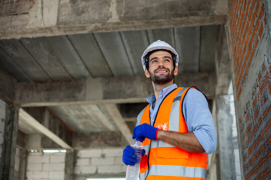 A Construction Worker Drinking Water. Workers Are Tired From Hard Work. Image Of Workers In Construction Work. Workers Drink Water.