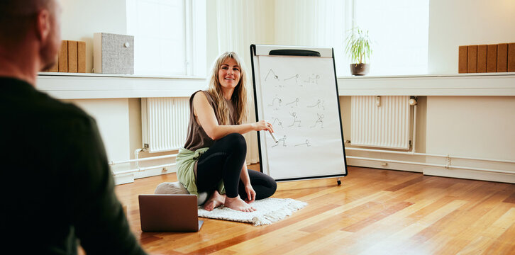 Smiling yoga teacher talking with students