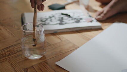 Obraz na płótnie Canvas Man hands clean paintbrush water glass closeup. Unrecognizable artist painting