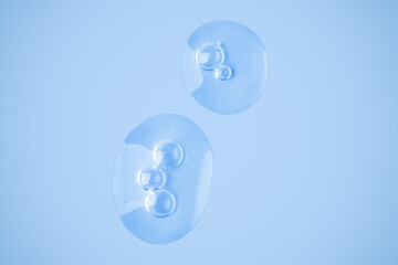 Drops of transparent gel. Strokes of gel. Smear. Gel.  On a blue background. Hyaluronic acid, toner, toner, gel, cream. Cosmetics.