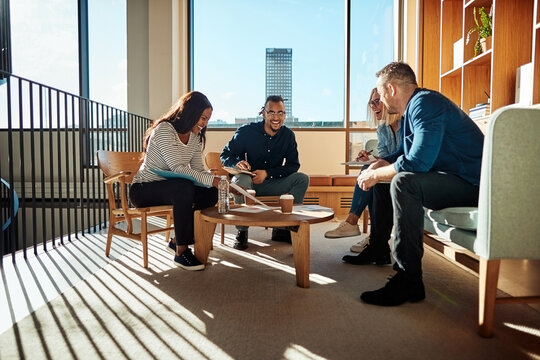 Diverse businesspeople laughing during a meeting in an office lounge