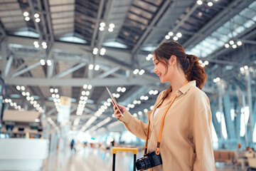 Happy asian tourist woman looking passport in Airport Terminal, Female on Vacation Trip, Tourist journey trip concept, copy space.