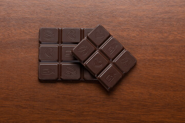 Dark chocolate chips on a woody background