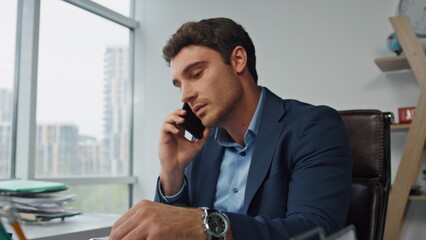 Smiling entrepreneur talking mobile phone closeup. Confident executive working