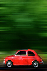 Small red generic car speeding in the country side.