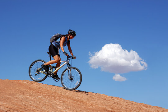 Woman mountain biking on slick rock in Moab, Utah