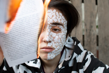 Face with burning sheet of paper, conceptual, close-up