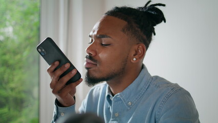 Serious man chatting cell indoors closeup. Modern freelancer talking loudspeaker