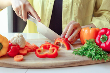 cut fresh vegetables with a knife, a woman uses a knife and cooks