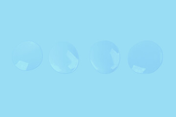 round drops of transparent gel serum on a blue background. gel with bubbles. Water droplets