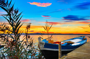 Fototapeta na wymiar paisaje de un lago con una barca y muchos colores