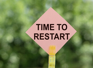 TIME TO RESTART text on a clipboard on green nature background
