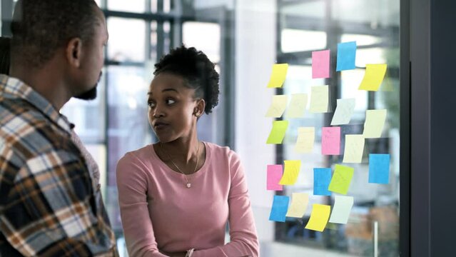 Planning, teamwork or designer with sticky notes writing for strategy, creative advertising or marketing idea on glass window. Manager, worker or employee with startup schedule or SEO mission agenda
