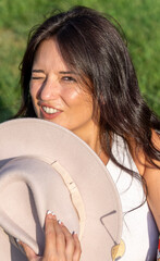 Woman looking at camera and winking an eye while enjoying a sunny day outdoors.