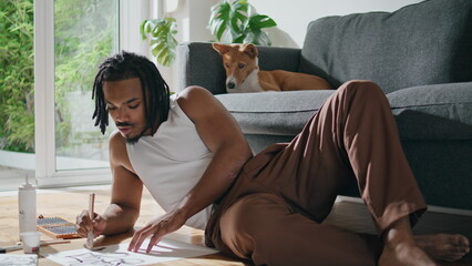 Inspired man creating artwork workshop. Domestic dog looking relaxing in studio
