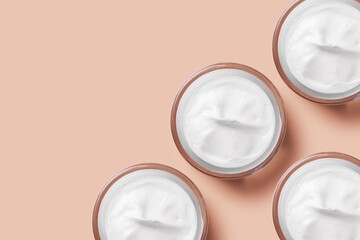 set of jars of cream in white on a beige background.