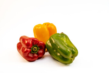 Pimientos de tres colores sobre fondo liso blanco, no gente