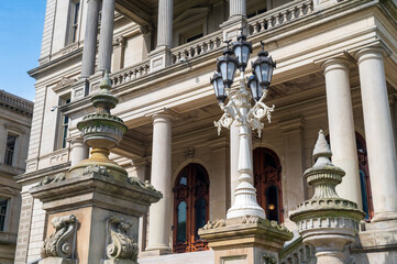 Fototapeta premium Lansing MI - May 6, 2023: Main entrance to the Michigan Capitol building with ornate masonry and lamppost