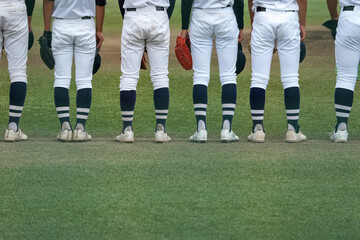 Obraz premium 野球の試合中に内野手がボール回しする間に声出しする補欠選手たち