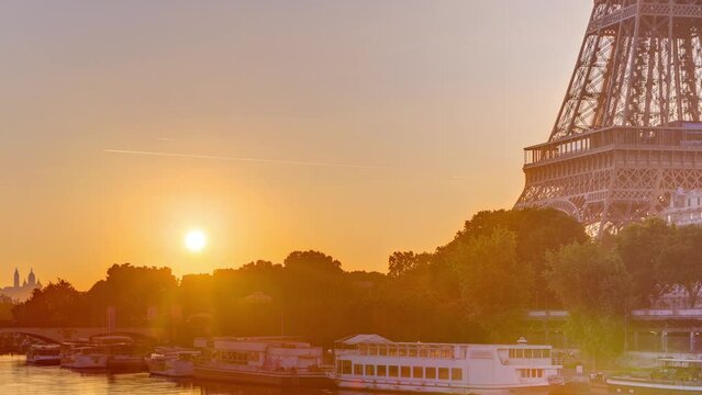 Eiffel Tower and the Seine river at Sunrise timelapse, Paris, France. Morning view from Bir-Hakeim bridge with reflections on water and orange sky