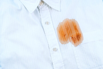 Close up of a dirty stain from sauce or coffee on a white shirt. Spoiled linen or clothes. Laundry...