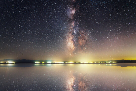 Beautiful night landscape. Bright Milky Way galaxy over the lake  with reflection 