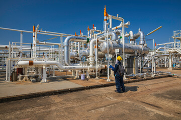 Male worker inspection at the exchanger of tank oil refinery pipeline plant steam vessel and column...