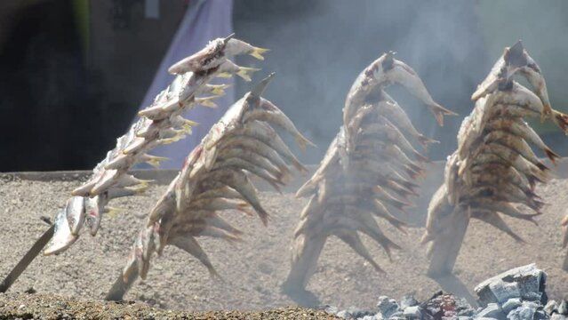 Sardines espetos at sea sand grilled at fire, typical spanish food