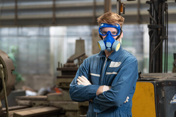 emergency pollution factory concept. Portrait engineer wearing a mechanical jumpsuit and gas mask looking at the camera with his arms crossed.