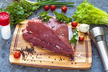 A piece of raw meat close-up on a dark background.